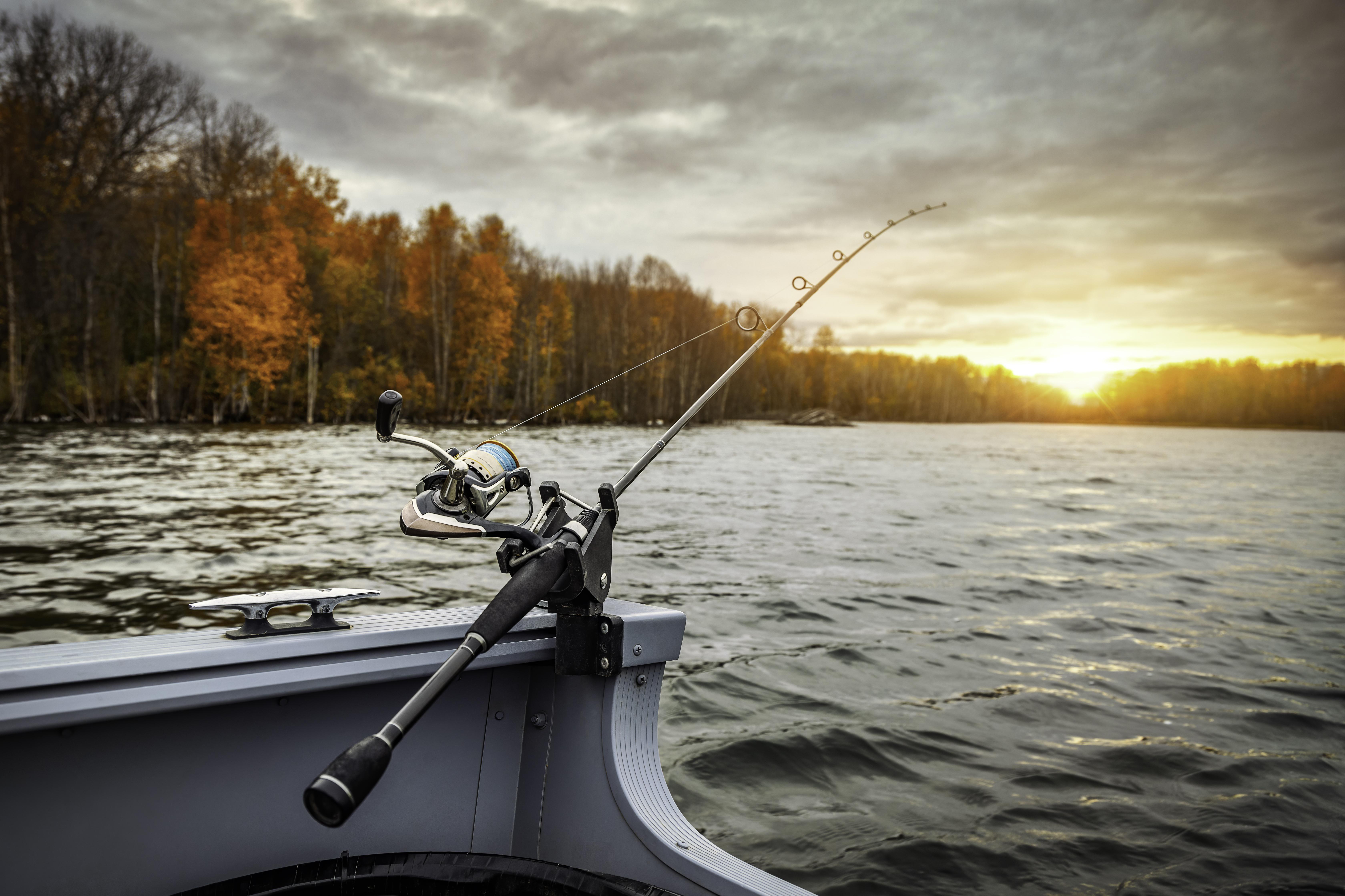 Fishing Rod Setup Fishing rod and reel on a boat at sunset